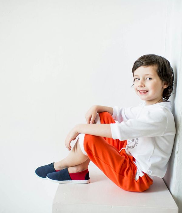 Happy child in a simple yoga pose in a bright, playful room.